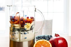 Making smoothies in blender with fruit and yogurt stock photo Making smoothies in blender with fruit and yogurt stock photo