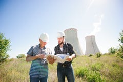 Male architects reviewing documents together at electric power plant. royalty free stock image Male architects reviewing documents together at electric power plant. royalty free stock image