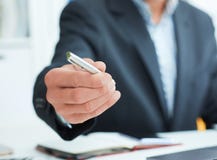 Male arm in suit offer silver pen to sign contract closeup. Strike a bargain for profit, white collar motivation, union Stock Images Male arm in suit offer silver pen to sign contract closeup. Strike a bargain for profit, white collar motivation, union Stock Images