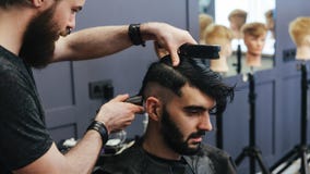 Male barber combing and shaving hair of a male client stock photos Male barber combing and shaving hair of a male client stock photos