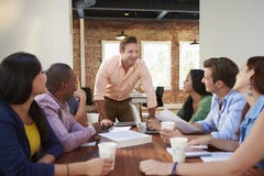Male Boss Addressing Office Workers At Meeting stock photography Male Boss Addressing Office Workers At Meeting stock photography