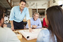 Male Boss Leading Meeting Of Architects Sitting At Table stock photography Male Boss Leading Meeting Of Architects Sitting At Table stock photography