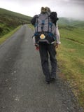 Male Camino pilgrim walking up the steep Pyrenees from St Jean. stock photography Male Camino pilgrim walking up the steep Pyrenees from St Jean. stock photography