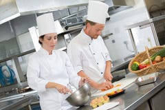 Male cooks preparing dishes in restaurant kitchen stock photo Male cooks preparing dishes in restaurant kitchen stock photo