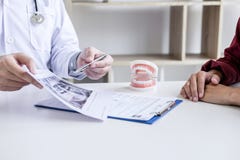 Male doctor or dentist writing report working with tooth x-ray film model and equipment used in the treatment of dental and stock photos Male doctor or dentist writing report working with tooth x-ray film model and equipment used in the treatment of dental and stock photos