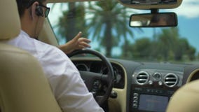 Male driving luxury car, having conversation over headset, busy businessman stock video Male driving luxury car, having conversation over headset, busy businessman stock video
