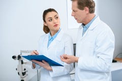 male and female ophthalmologists writing diagnosis stock photography male and female ophthalmologists writing diagnosis stock photography