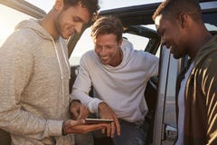 Male friends planning road trip route with tablet computer stock photos Male friends planning road trip route with tablet computer stock photos