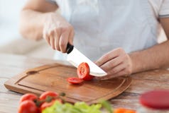 Male hand cutting tomato on board with knife Stock Photography Male hand cutting tomato on board with knife Stock Photography