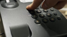 Male hand dials emergency number on the phone