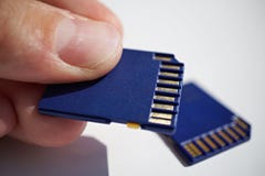 Male Hand Holding A Memory Card (SD Card - Secure Digital Card) Used In Video Cameras And Computers In Blue Color Stock Photography Male Hand Holding A Memory Card (SD Card - Secure Digital Card) Used In Video Cameras And Computers In Blue Color Stock Photography