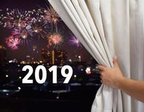 Male hand open the window curtain and see firework on night city sky background , celebration new year 2019 stock image Male hand open the window curtain and see firework on night city sky background , celebration new year 2019 stock image