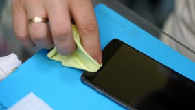 Male hands holding and cleaning a mobile phone screen to put on, apply a protective tempered glass to Protect a stock footage Male hands holding and cleaning a mobile phone screen to put on, apply a protective tempered glass to Protect a stock footage