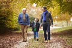Male Multl Generation Family Walking Along Autumn Path Stock Images Male Multl Generation Family Walking Along Autumn Path Stock Images