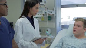 Male Patient Talking To Medical Staff In Emergency Room stock video Male Patient Talking To Medical Staff In Emergency Room stock video
