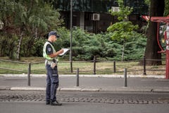Male Serbian police officer in uniform writing a ticket in Belgrade. He belongs to the civilian police force of the country royalty free stock images Male Serbian police officer in uniform writing a ticket in Belgrade. He belongs to the civilian police force of the country royalty free stock images