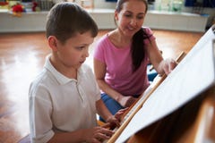 Male Student Enjoying Piano Lesson With Teacher stock image Male Student Enjoying Piano Lesson With Teacher stock image