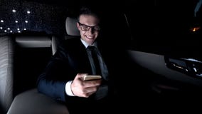 Male in suit texting with girlfriend on back seat of car as driving home, flirt royalty free stock image Male in suit texting with girlfriend on back seat of car as driving home, flirt royalty free stock image