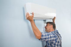Male technician fixing air conditioner Stock Photo Male technician fixing air conditioner Stock Photo