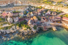 Malta, IL-Mellieha Vista de la opinión aérea y de la bahía de Popeye del pueblo famoso famoso en una luz de la puesta del sol fotos de archivo libres de regalías Malta, IL-Mellieha Vista de la opinión aérea y de la bahía de Popeye del pueblo famoso famoso en una luz de la puesta del sol fotos de archivo libres de regalías