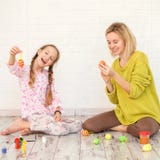 Mama i dziecko dekorujemy Wielkanocnych jajka zdjęcie stock Mama i dziecko dekorujemy Wielkanocnych jajka zdjęcie stock