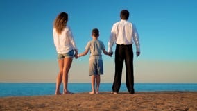 Mama, tata i syn, jesteśmy trwanie na plaży i patrzeć w odległość zbiory Mama, tata i syn, jesteśmy trwanie na plaży i patrzeć w odległość zbiory