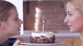 Maman de joyeux anniversaire, jeune mère avec les bougies de soufflement de fille d'enfant sur le gâteau de vacances et sourires Maman de joyeux anniversaire, jeune mère avec les bougies de soufflement de fille d'enfant sur le gâteau de vacances et sourires