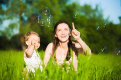 Maman et petite fille attrapant gaiement des bulles de savon photos stock Maman et petite fille attrapant gaiement des bulles de savon photos stock