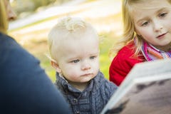 Maman lisant un livre à ses deux enfants blonds adorables images stock Maman lisant un livre à ses deux enfants blonds adorables images stock