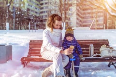 Mamma met een jongenszoon 3 jaar oud, in de winter in een paar op een bank, verse lucht De stadspark van het vakantieweekend Foto stock fotografie Mamma met een jongenszoon 3 jaar oud, in de winter in een paar op een bank, verse lucht De stadspark van het vakantieweekend Foto stock fotografie
