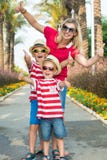 Mamma och son två i solglasögon och hattar som går till och med gränden av palmträd Familjsommarsemester arkivfoto Mamma och son två i solglasögon och hattar som går till och med gränden av palmträd Familjsommarsemester arkivfoto