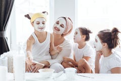 Mamã com suas filhas que fazem a máscara protetora da argila imagens de stock Mamã com suas filhas que fazem a máscara protetora da argila imagens de stock