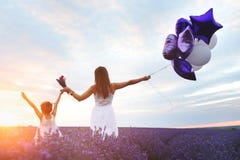A mamã e a filha na alfazema colocam no por do sol Conceito do amor da família imagem de stock A mamã e a filha na alfazema colocam no por do sol Conceito do amor da família imagem de stock