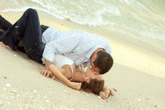 Man And Woman Kissing On Beach In Wet Clothes Stock Images