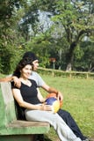 Man And Woman Sitting On A Park Bench - Vertical Royalty Free Stock Photography