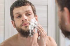Man is applying shaving foam to his face preparing to shave Stock Photo Man is applying shaving foam to his face preparing to shave Stock Photo