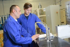 Man and apprentice looking at machinery royalty free stock photography Man and apprentice looking at machinery royalty free stock photography