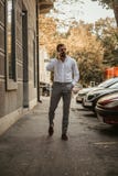 Man att gå på trottoaren och samtal på telefonen royaltyfri foto Man att gå på trottoaren och samtal på telefonen royaltyfri foto