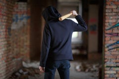 A man with a bat on his shoulder is standing on an abandoned building royalty free stock photos A man with a bat on his shoulder is standing on an abandoned building royalty free stock photos