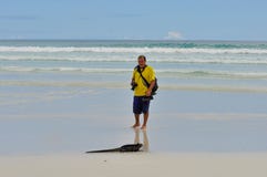 A man on the beach with a marine iguana royalty free stock photos A man on the beach with a marine iguana royalty free stock photos