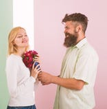 Man with beard congratulates woman birthday anniversary holiday. Hipster bearded give bouquet flowers to girlfriend royalty free stock image Man with beard congratulates woman birthday anniversary holiday. Hipster bearded give bouquet flowers to girlfriend royalty free stock image