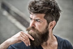 Man with beard and mustache looks thoughtful or troubled Bearded man on concentrated face touches beard. Hipster with Royalty Free Stock Photography Man with beard and mustache looks thoughtful or troubled Bearded man on concentrated face touches beard. Hipster with Royalty Free Stock Photography