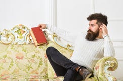 Man with beard and mustache spends leisure with book. Scientist, professor on strict face analyzing literature. Self Stock Photos Man with beard and mustache spends leisure with book. Scientist, professor on strict face analyzing literature. Self Stock Photos
