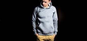 Man in the blank grey hoodie, sweatshirt on a black background, mock up, free space royalty free stock photos Man in the blank grey hoodie, sweatshirt on a black background, mock up, free space royalty free stock photos