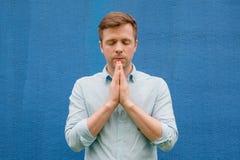 Man in blue shirt meditating or praying to God stock image Man in blue shirt meditating or praying to God stock image