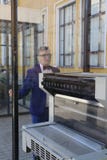 Man in a blue suit looks at the printing press behind the glass royalty free stock image Man in a blue suit looks at the printing press behind the glass royalty free stock image