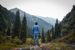 Man in Blue and White Checked Quarter-sleeved Shirt Holding Black Camera Standing on Rock Stock Photography Man in Blue and White Checked Quarter-sleeved Shirt Holding Black Camera Standing on Rock Stock Photography