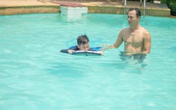 Man and boy play in the water in the swimming pool stock photo Man and boy play in the water in the swimming pool stock photo