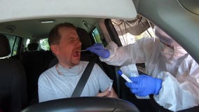 Man in car having oral swab PCR test for possible infection
