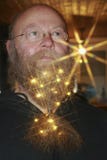 Man with chain of lights, with sparkling asterisks in his beard